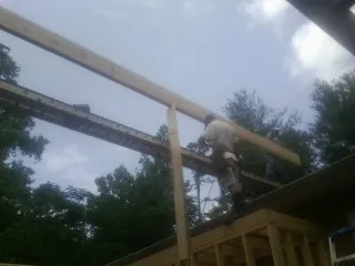 Carpenter setting a ridge beam over a new addition frame — Ice Dam Removal by Roofing Brothers in Huntington Park