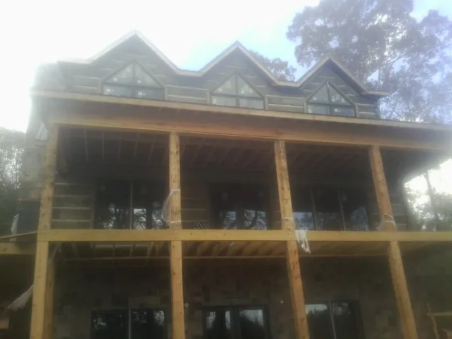 Dormers and porch framing on a large log home under construction — Roof Coating work by our crew in Huntington Park