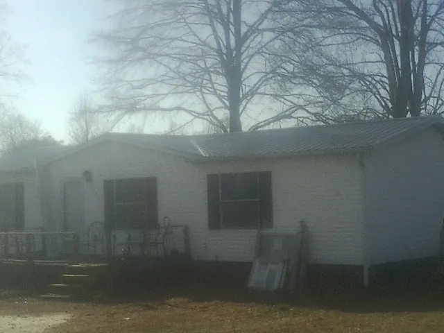 New metal roof on a white painted brick home on a foggy morning in Huntington Park