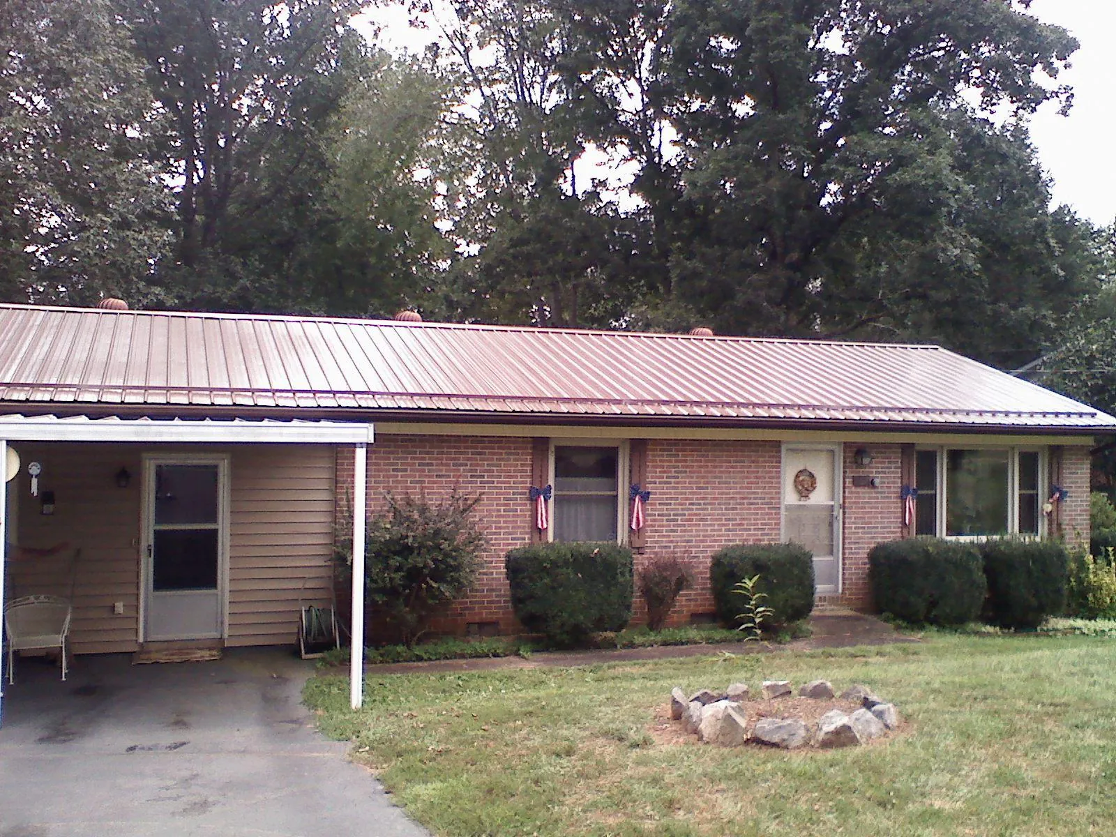Bronze metal roof and carport on a brick ranch home — Roof Repair work by our crew in Huntington Park